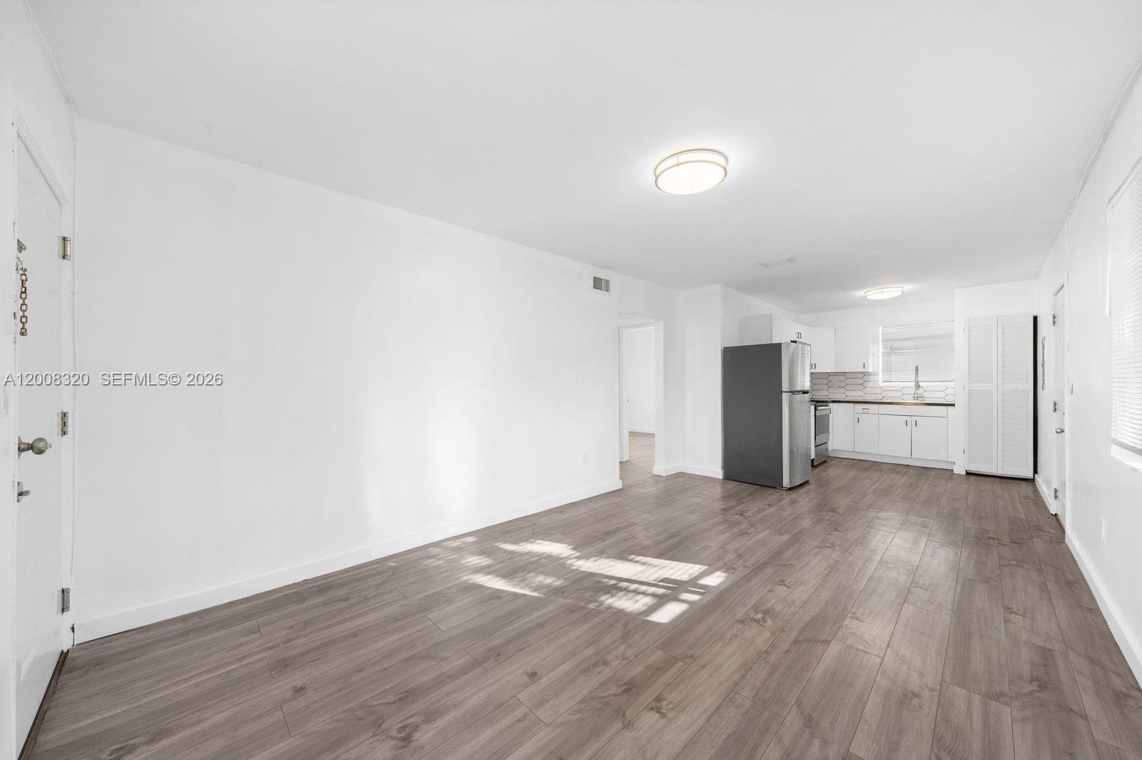 842 Southwest 3rd Street Miami, FL 33130 - Photo 7 of 13 a view of a kitchen with wooden floor and a refrigerator