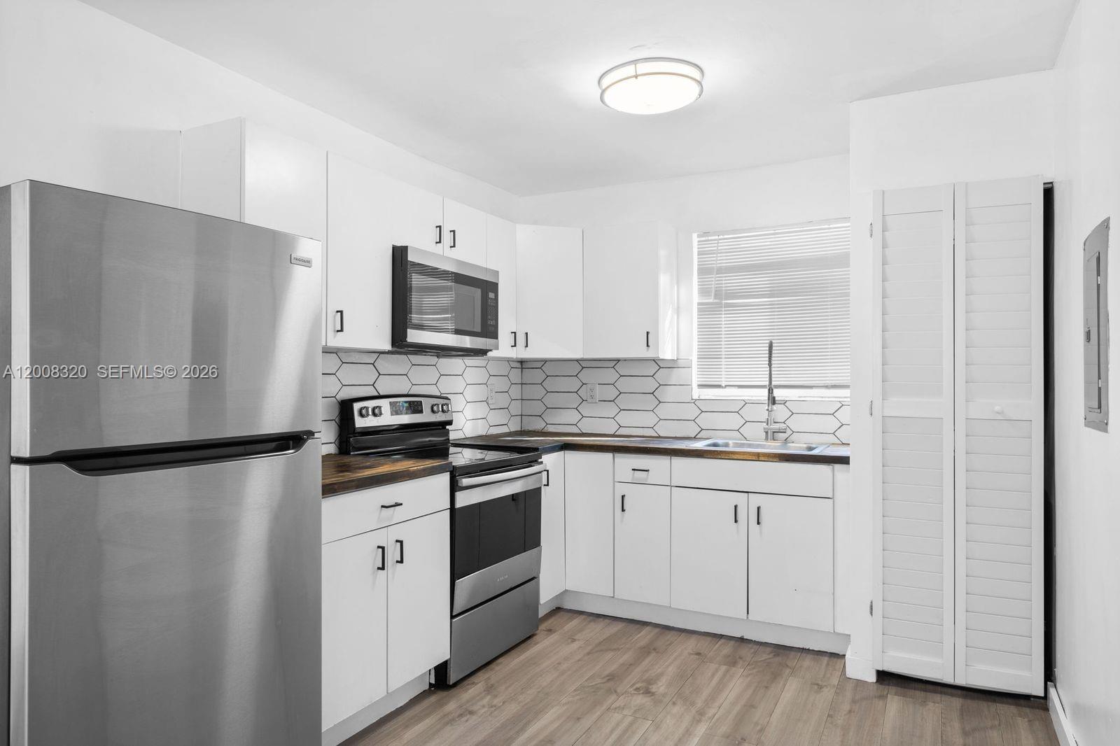 842 Southwest 3rd Street Miami, FL 33130 - Photo 8 of 13 a kitchen with granite countertop a refrigerator stove and sink