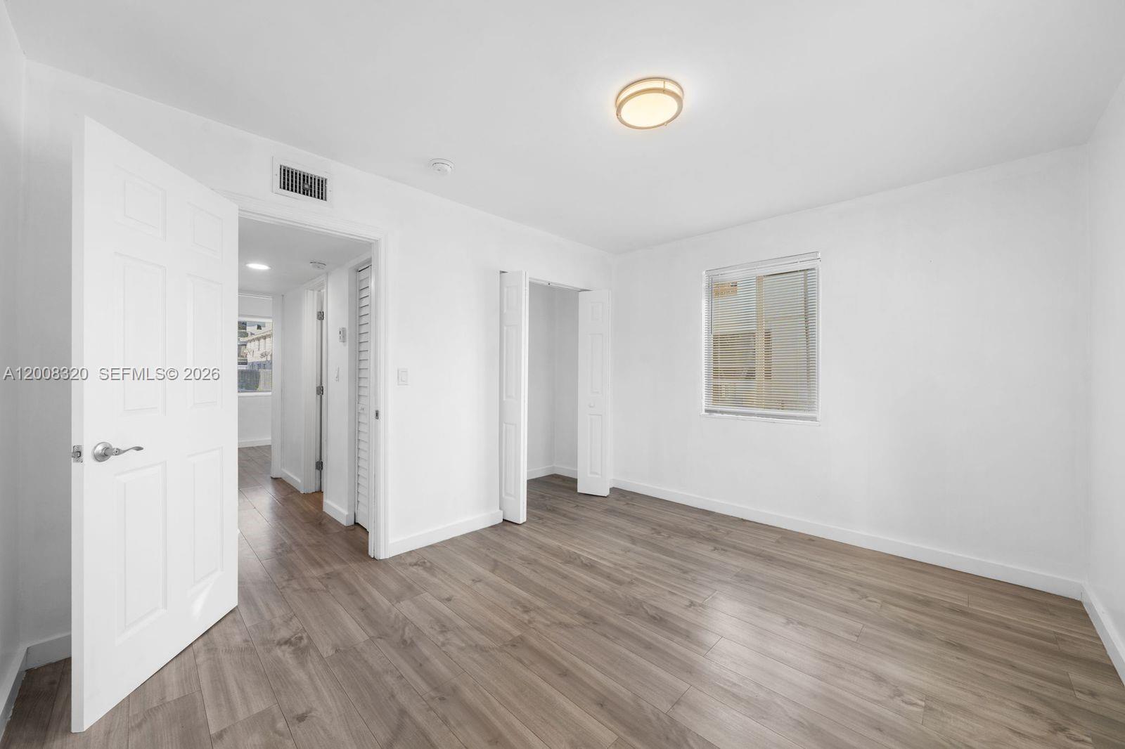 842 Southwest 3rd Street Miami, FL 33130 - Photo 9 of 13 an empty room with wooden floor and a window