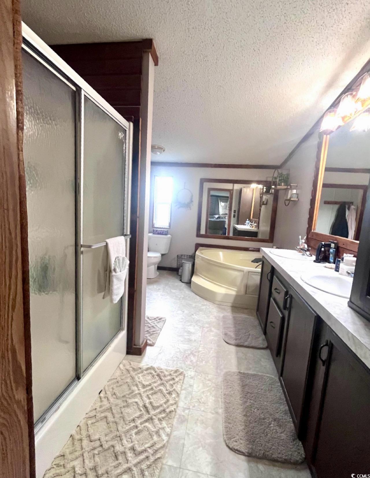 7096 Johnson Shortcut Road Conway, SC 29527 - Photo 11 of 16 Full bath featuring a shower stall, a textured ceiling, double vanity, and a garden tub