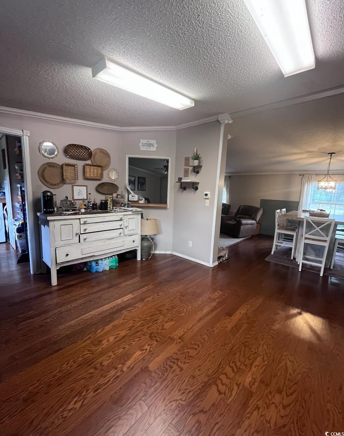7096 Johnson Shortcut Road Conway, SC 29527 - Photo 8 of 16 Living room with a textured ceiling, dark wood-style floors, and ornamental molding
