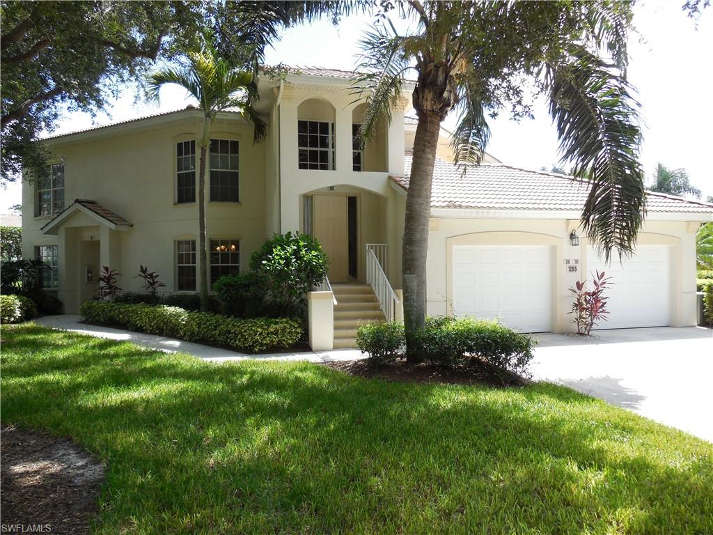 1265 Egrets Landing, Unit 101 Naples, FL 34108 - Photo 1 of 28 a front view of a house with a garden and plants