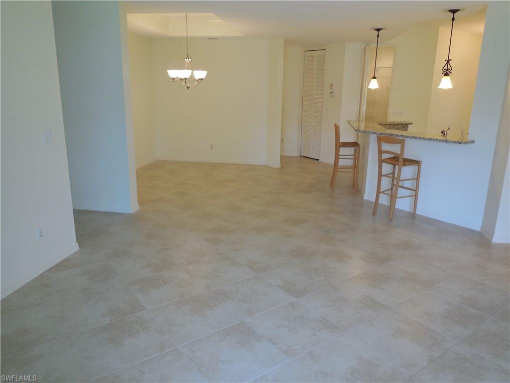 1265 Egrets Landing, Unit 101 Naples, FL 34108 - Photo 12 of 28 a view of a livingroom with furniture and a chandelier