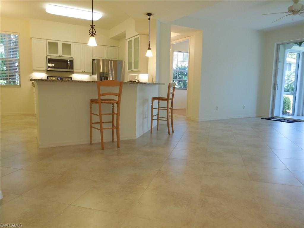 1265 Egrets Landing, Unit 101 Naples, FL 34108 - Photo 17 of 28 a view of kitchen with furniture and wooden floor
