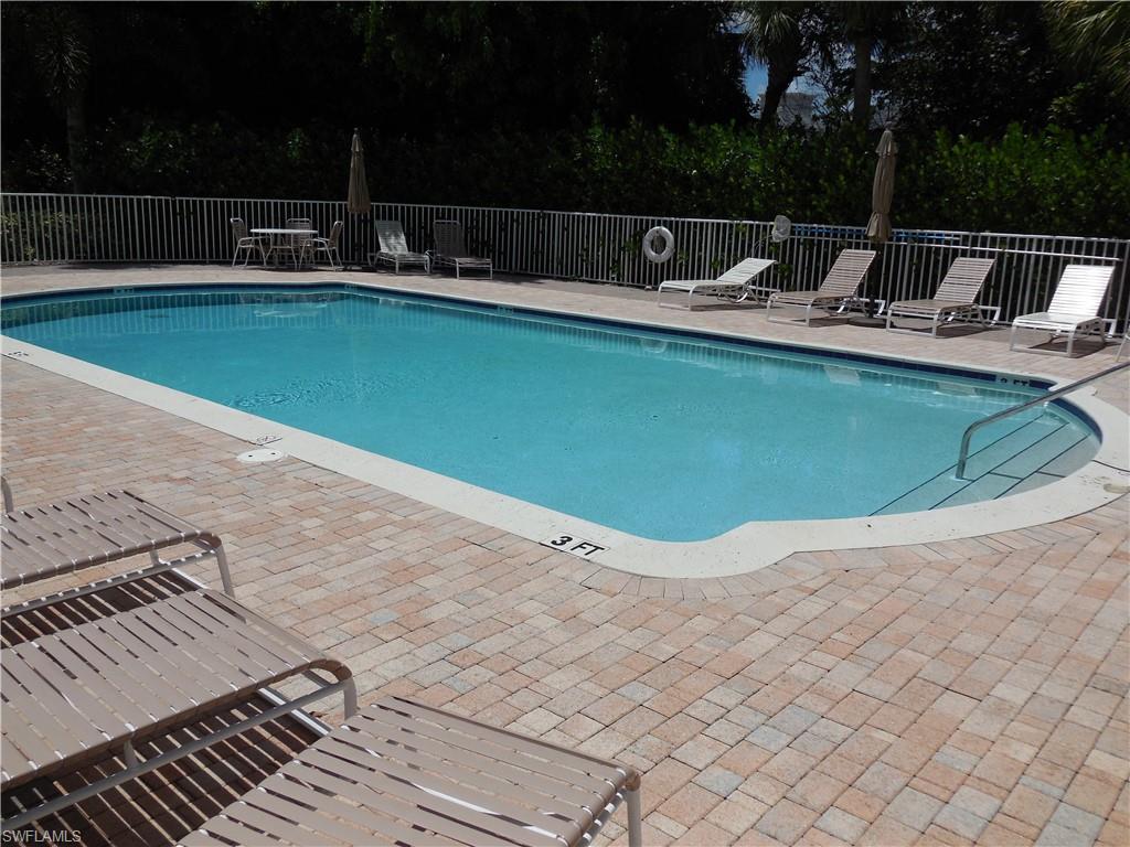1265 Egrets Landing, Unit 101 Naples, FL 34108 - Photo 27 of 28 a view of backyard with swimming pool and seating space