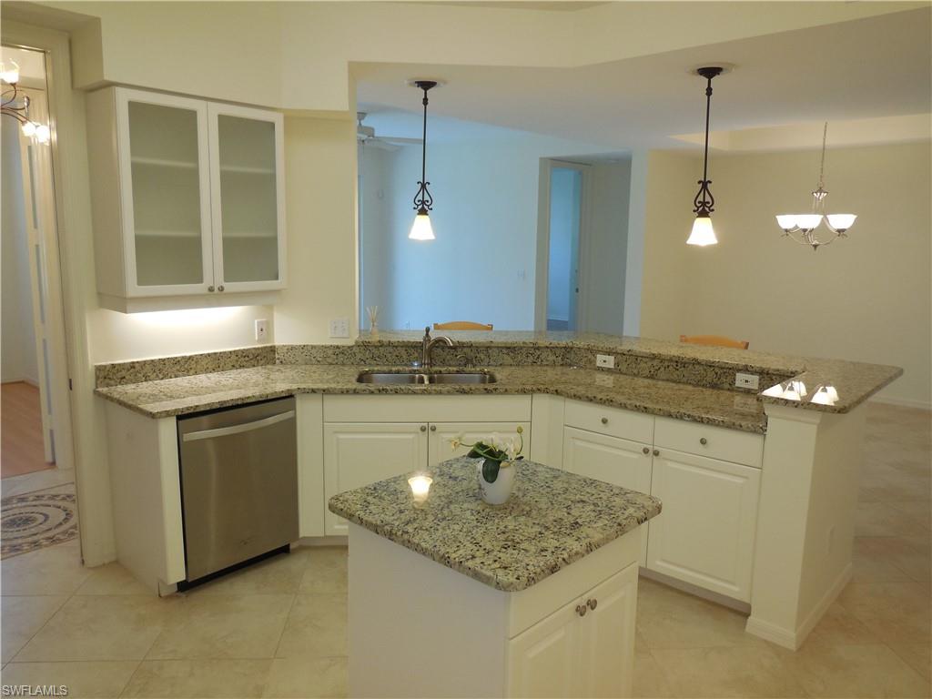 1265 Egrets Landing, Unit 101 Naples, FL 34108 - Photo 5 of 28 a kitchen with a sink stove and cabinets