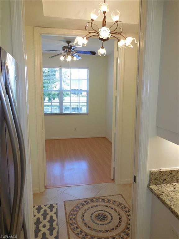 1265 Egrets Landing, Unit 101 Naples, FL 34108 - Photo 7 of 28 a view of a livingroom with furniture and chandelier fan