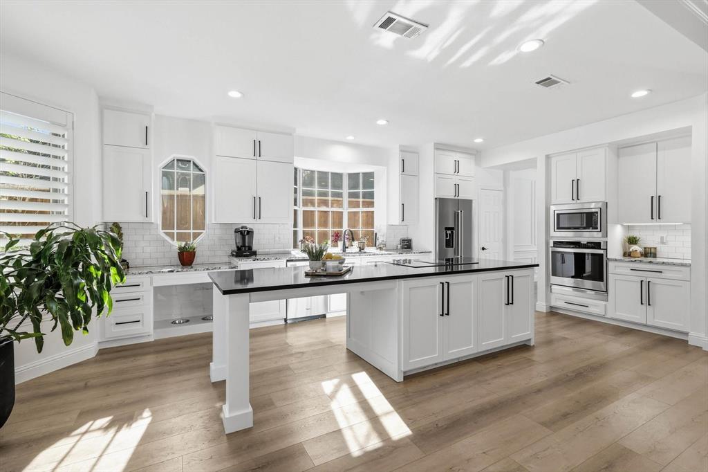 3408 Druid Way Flower Mound, TX 75028 - Photo 3 of 36 a kitchen with sink cabinets and wooden floor