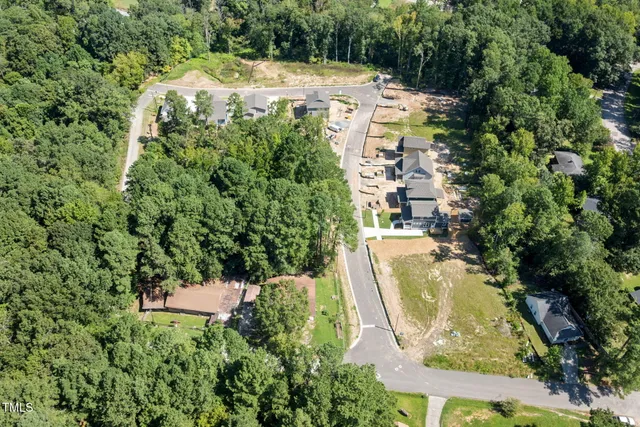 an aerial view of a house with a yard and large trees