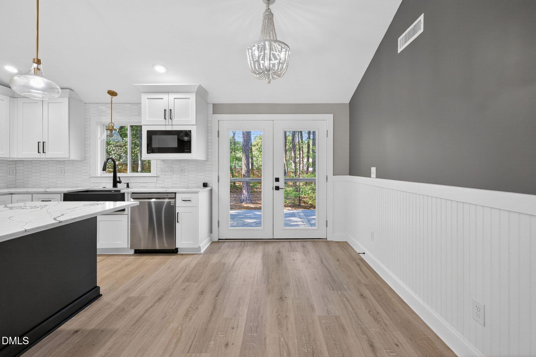 313 Crown Oaks Drive Raleigh, NC 27615 - Photo 13 of 60 a kitchen with wooden floors and white appliances