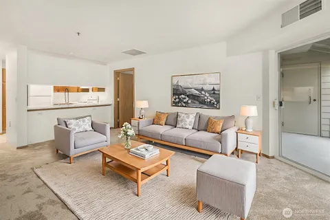 a living room with furniture a rug and a painting on the wall