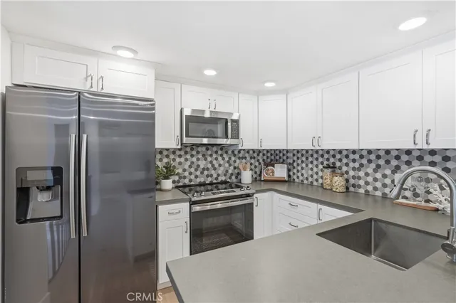 a kitchen with a refrigerator sink and stainless steel appliances