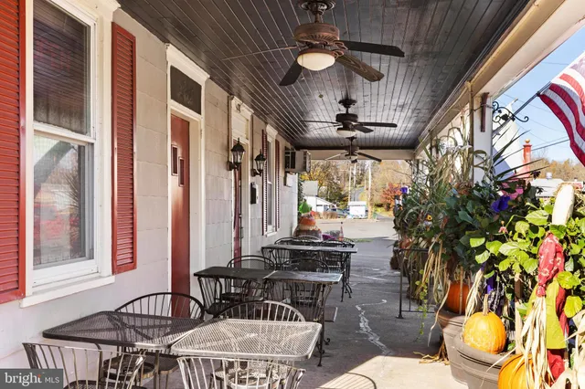 a view of a patio with couches table and chairs and potted plants
