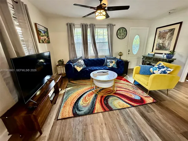 a living room with furniture and a wooden floor