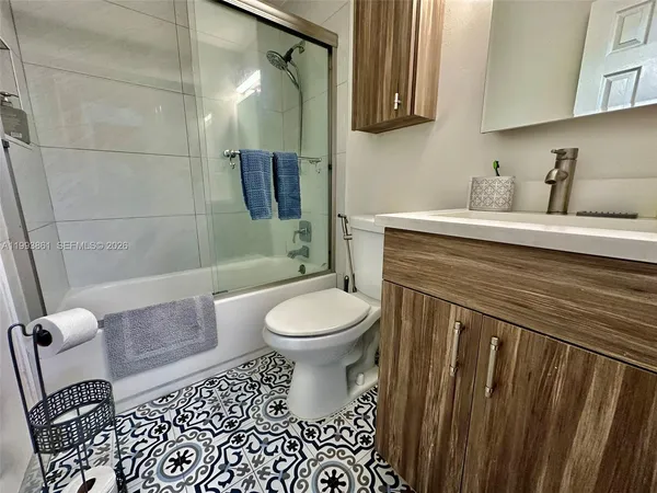 a bathroom with a toilet a sink and mirror