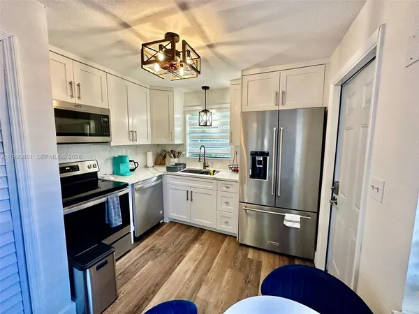 a kitchen with stainless steel appliances a refrigerator sink and microwave