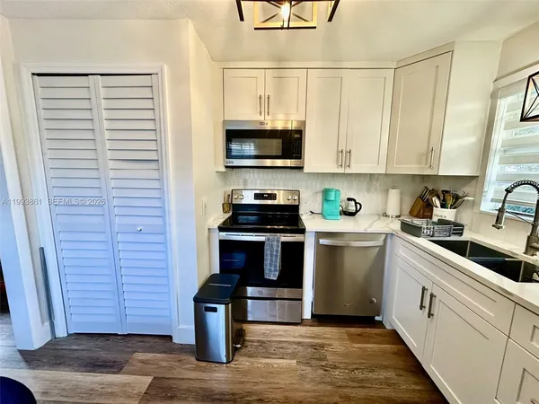 a kitchen with cabinets a sink and appliances