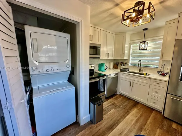 a kitchen with a sink cabinets and wooden floor
