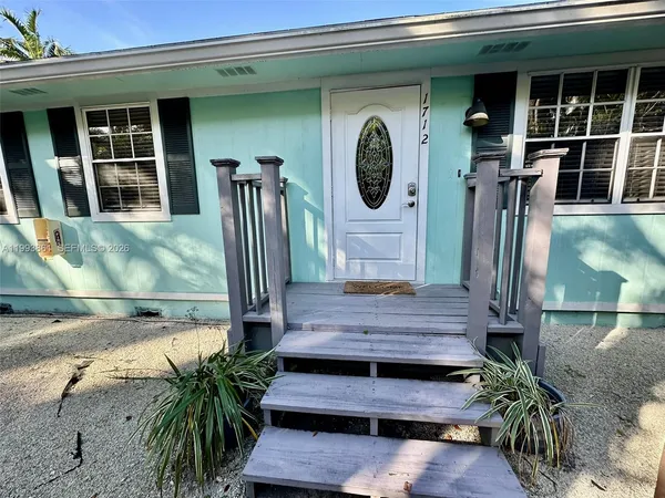 a view of front door of house with potted plants