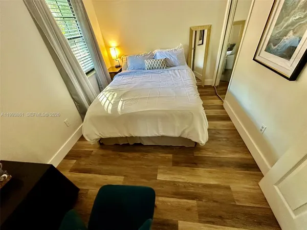 a bed sitting in a bedroom next to a small bathroom