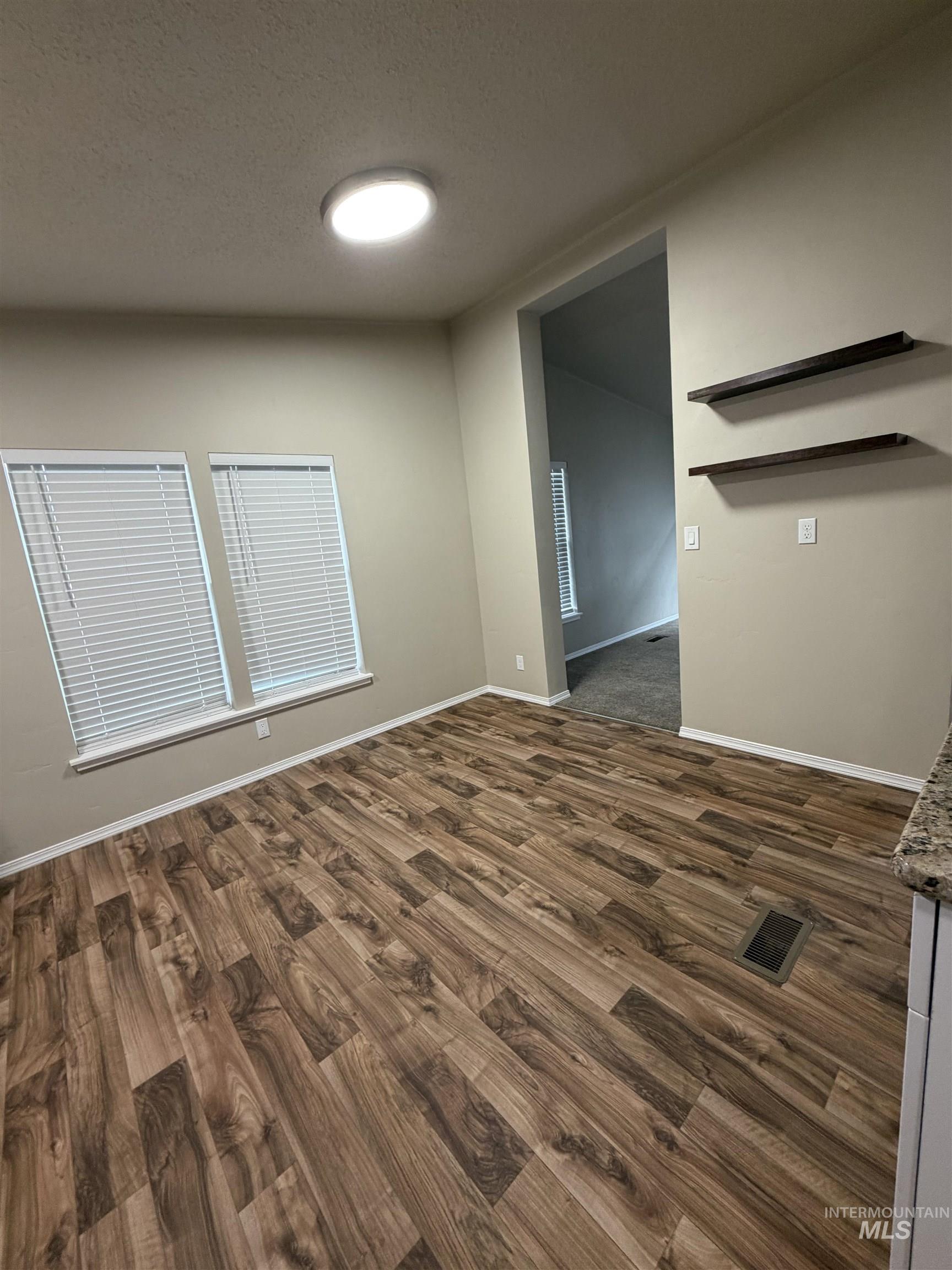 815 East Liberty Street Weiser, ID 83672 - Photo 10 of 25 Unfurnished room with dark wood-style floors and a textured ceiling