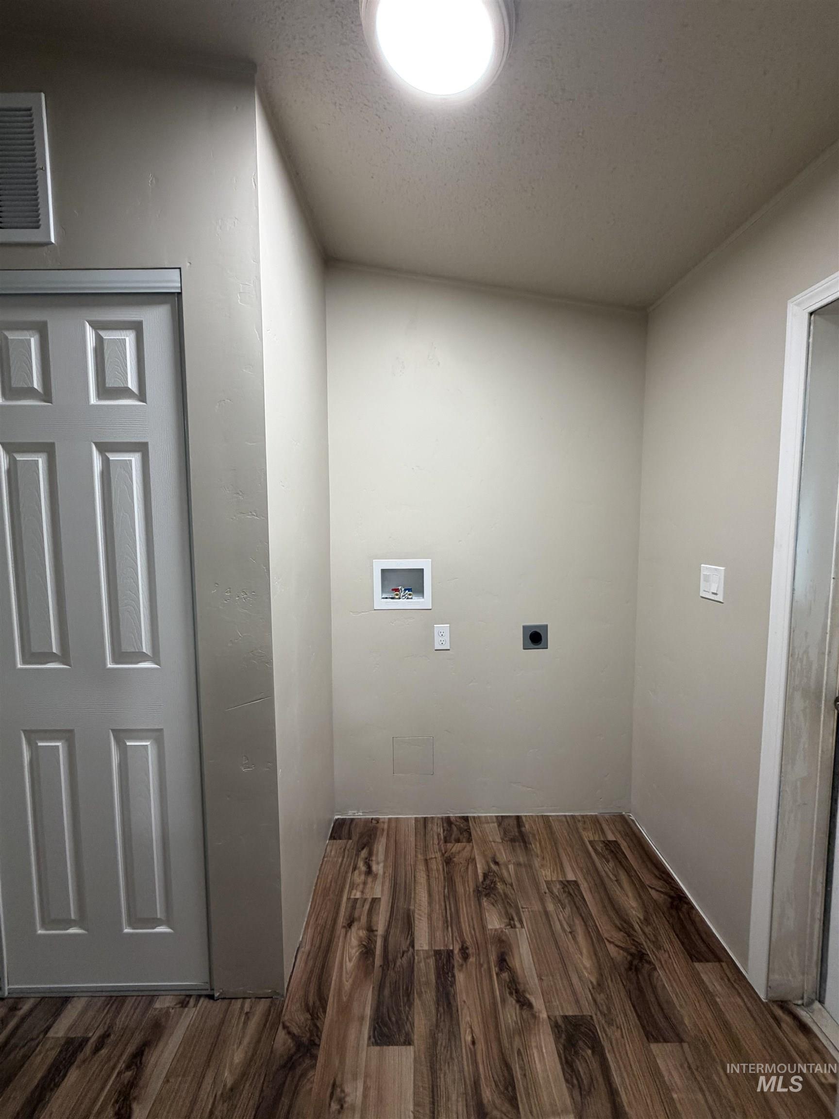 815 East Liberty Street Weiser, ID 83672 - Photo 19 of 25 Laundry room featuring dark wood-style floors, washer hookup, a textured ceiling, and electric dryer hookup