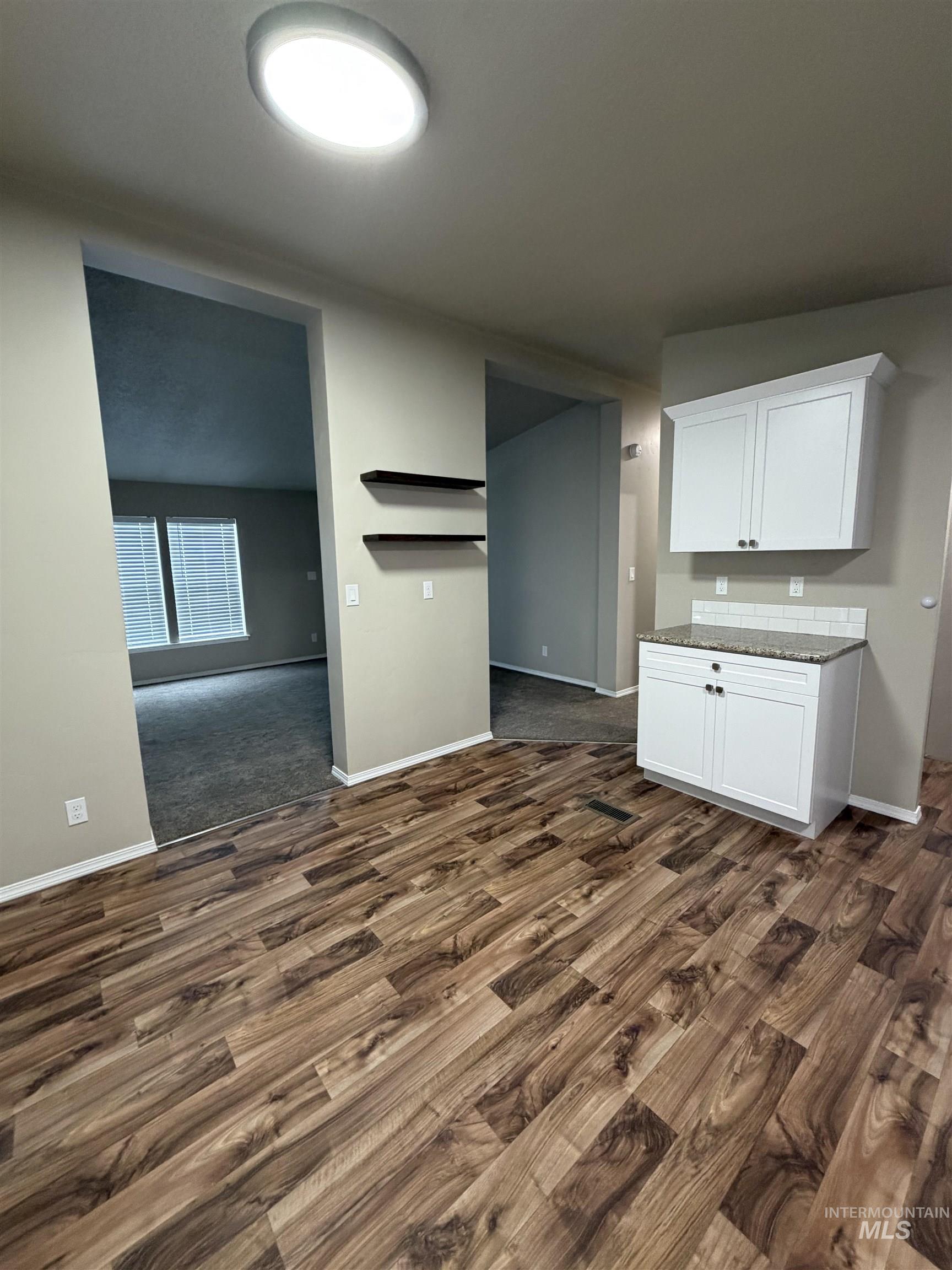 815 East Liberty Street Weiser, ID 83672 - Photo 8 of 25 Kitchen with white cabinets, dark stone countertops, and dark wood-style floors
