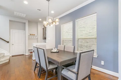 a view of a dining room with furniture a chandelier and wooden floor