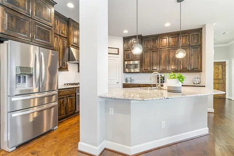 a kitchen with stainless steel appliances granite countertop a sink a stove and a refrigerator