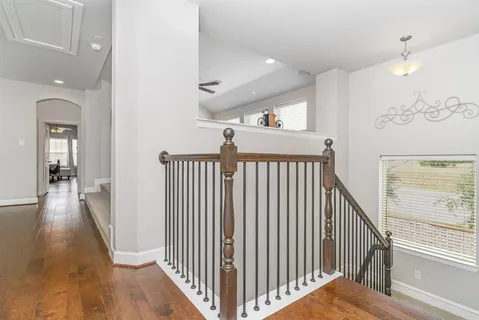 a view of a hallway with wooden floor and stairs