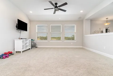 a view of livingroom with furniture flat screen tv and a ceiling fan