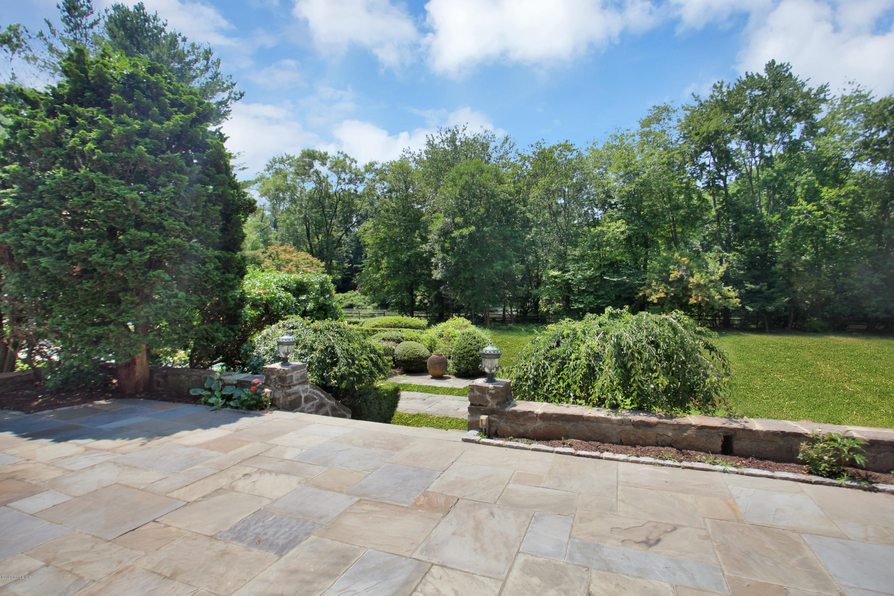 558 Lake Avenue Greenwich, CT 06830 - Photo 24 of 28 a view of a garden with a bench in a garden