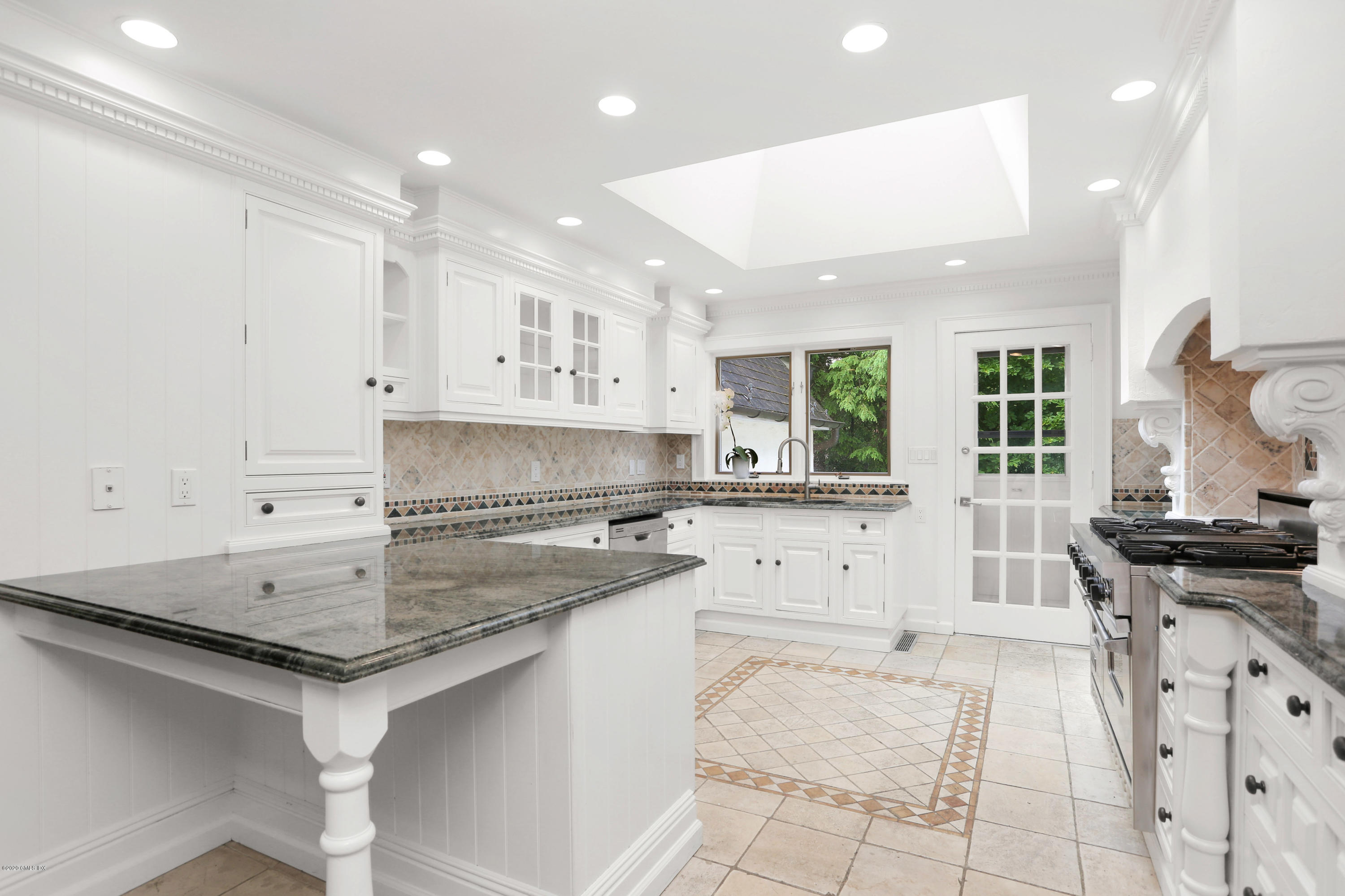 558 Lake Avenue Greenwich, CT 06830 - Photo 9 of 28 a kitchen with granite countertop a sink stove and cabinets