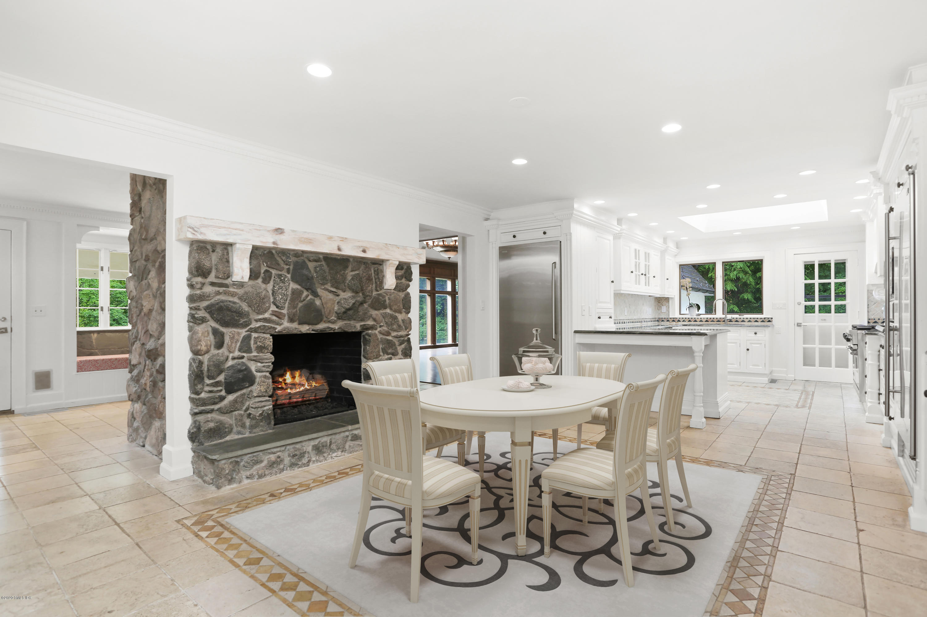 558 Lake Avenue Greenwich, CT 06830 - Photo 10 of 28 a dining room with furniture and a fireplace