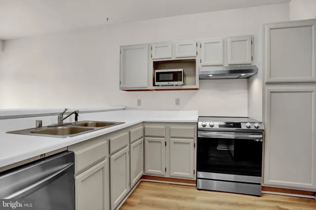 a kitchen with white cabinets and stainless steel appliances