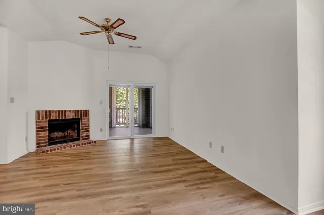 a view of an empty room with window and fire place