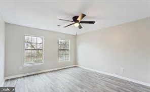 a view of a room with wooden floor and windows