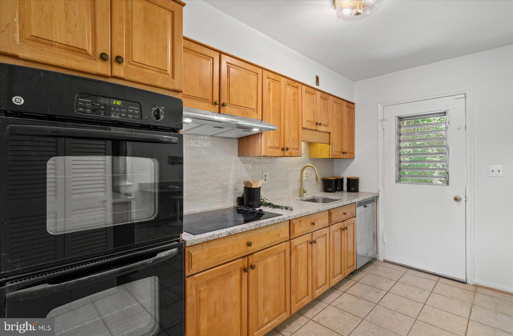 2300 Musgrove Road Silver Spring, MD 20904 - Photo 22 of 41 a kitchen with stainless steel appliances granite countertop a stove a sink and cabinets