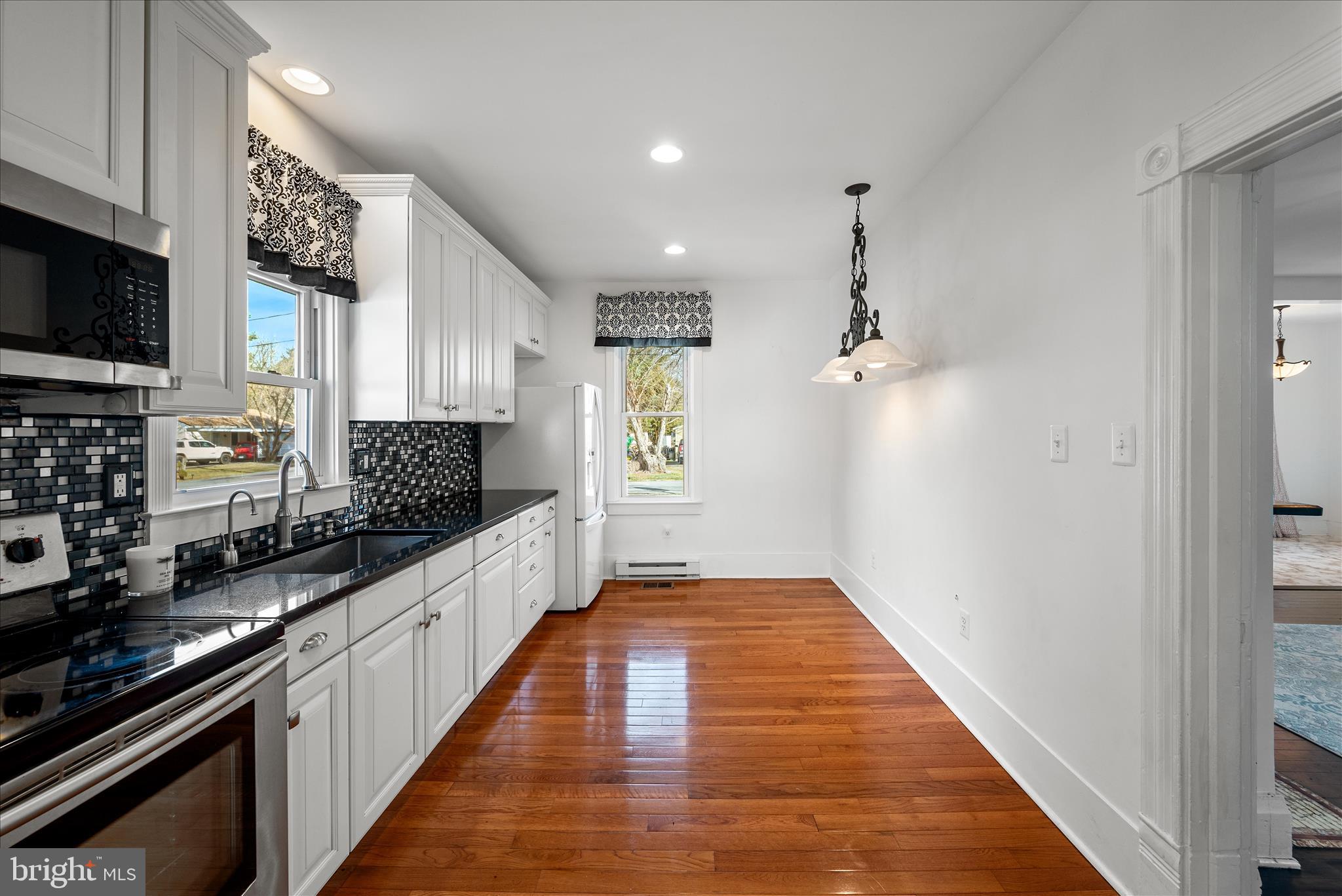 129 Church Street Summit Point, WV 25446 - Photo 44 of 91 a large kitchen with stainless steel appliances a large counter top a stove a chimney a sink and a refrigerator