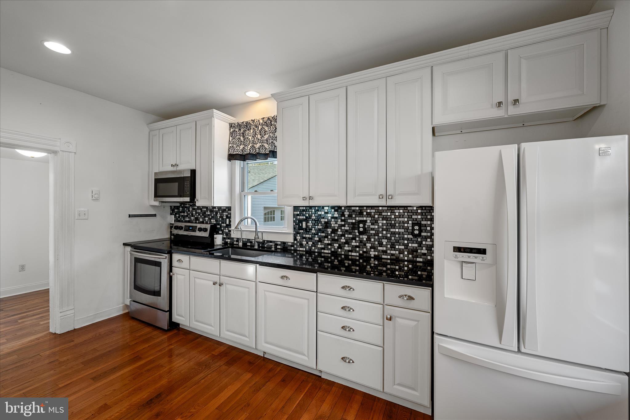 129 Church Street Summit Point, WV 25446 - Photo 46 of 91 a kitchen with granite countertop white cabinets and stainless steel appliances