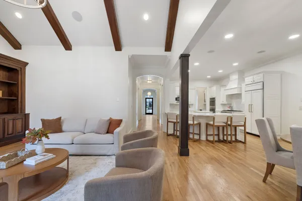 a living room with furniture and a dining table with wooden floor