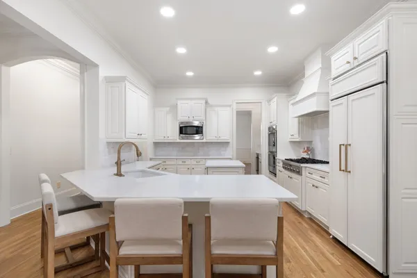 a kitchen with a dining table chairs refrigerator and cabinets
