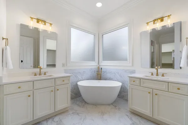 a spacious bathroom with a double vanity sink mirror and bathtub