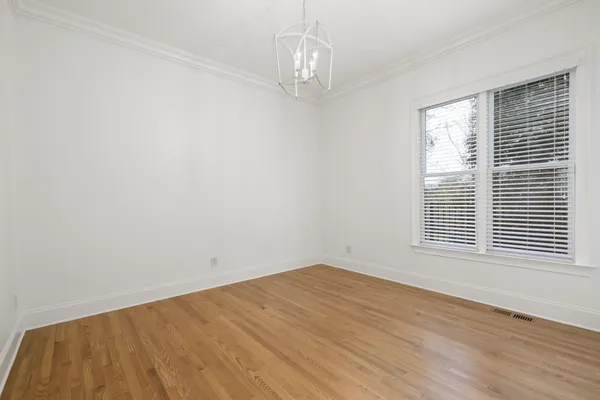 a view of a big room with wooden floor and windows