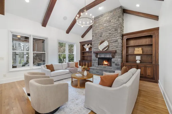 a living room with furniture a large window and a fireplace