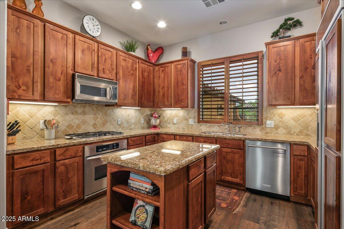 20704 North 90th Place, Unit 1004 Scottsdale, AZ 85255 - Photo 14 of 28 a kitchen with granite countertop stainless steel appliances a stove sink and microwave