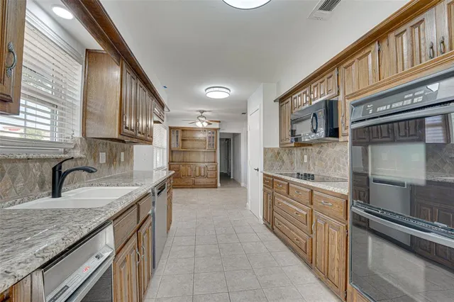 a kitchen with stainless steel appliances granite countertop a sink stove and refrigerator
