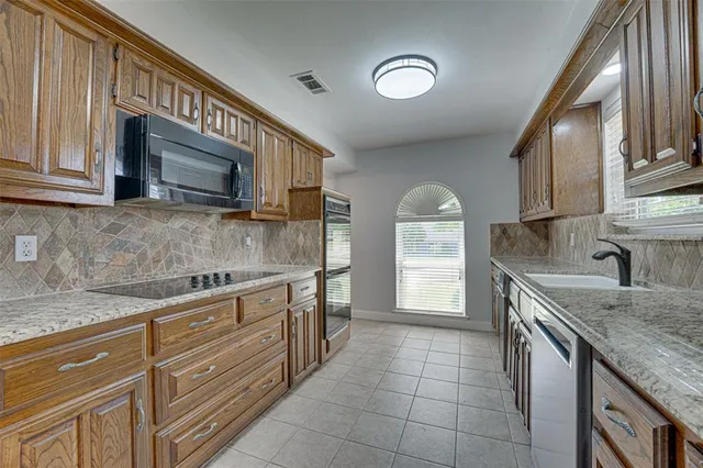 a kitchen with a sink stove top oven and cabinets