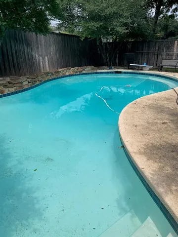 a view of a backyard with wooden fence