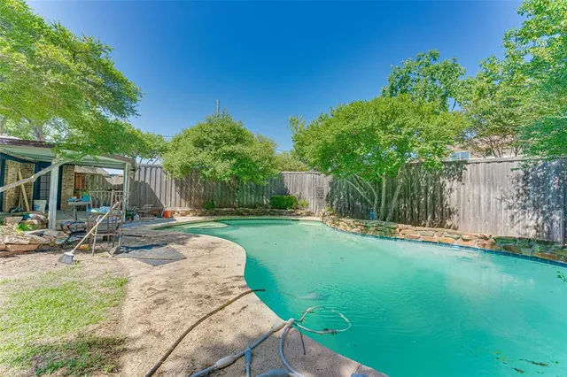 a view of a backyard with a slide trees and wooden fence